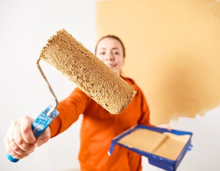 Smiling caucasian woman painting interior wall of home. Renovation apartment. repair and redecoration concept. copy space